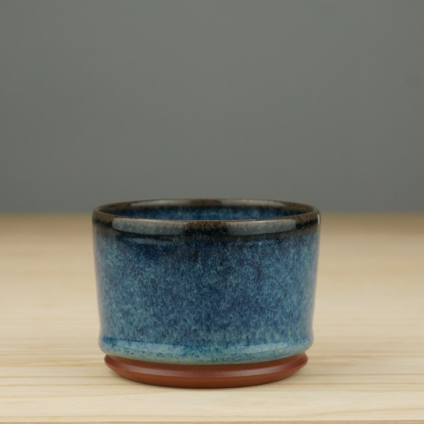 Becher aus rotem Ton, glasiert mit blauen Farbeffekten und Tropfenbildung