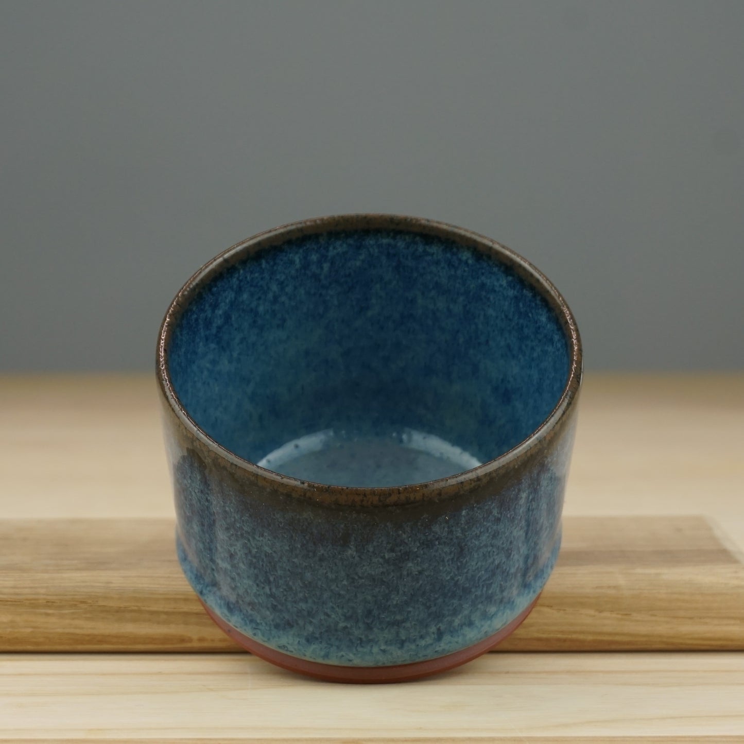 Becher aus rotem Ton, glasiert mit blauen Farbeffekten und Tropfenbildung